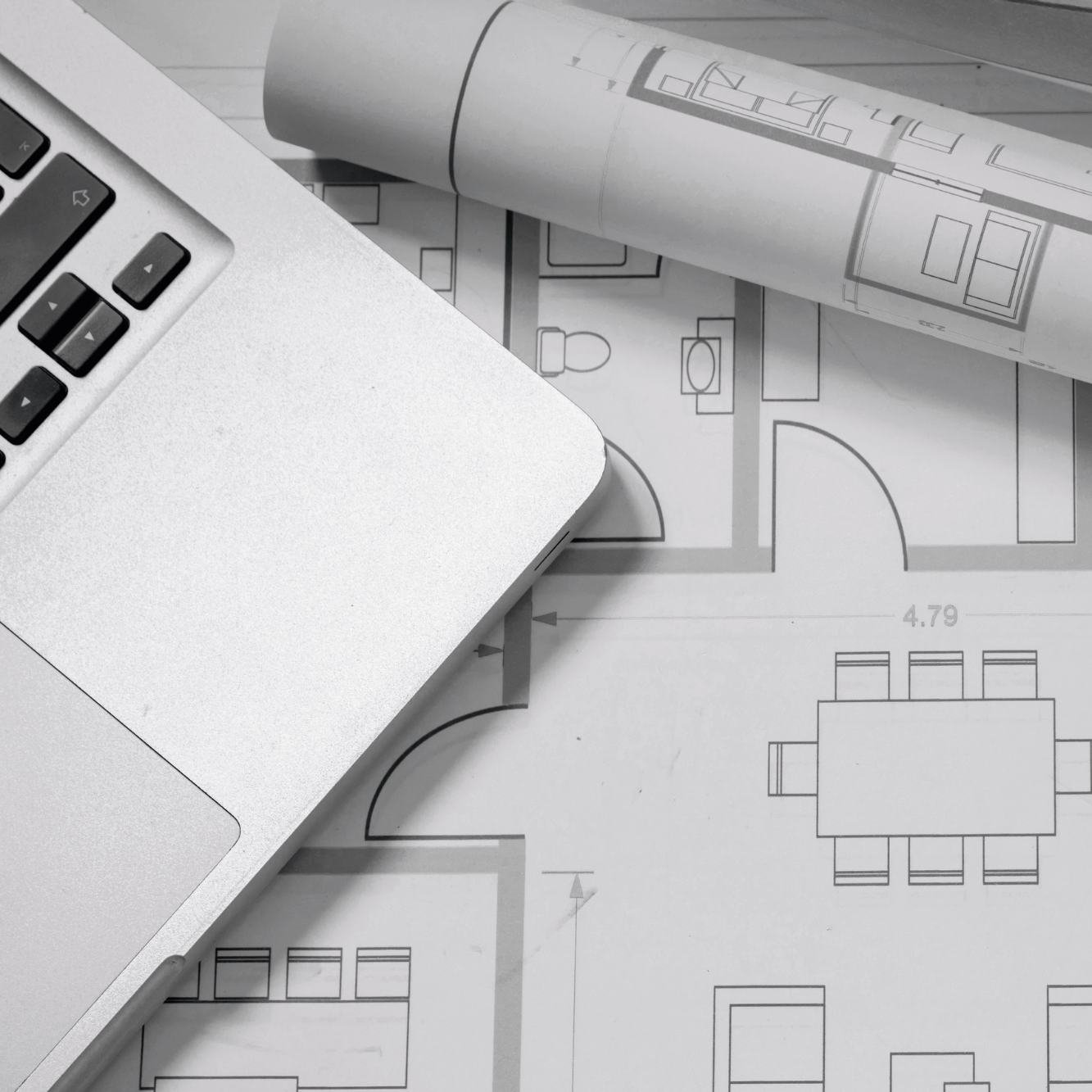 Plan de maison avec un ordinateur portable et un rouleau de plans.