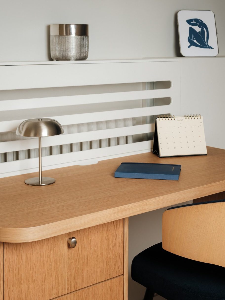 Bureau en bois clair avec lampes, agenda et décor minimaliste.