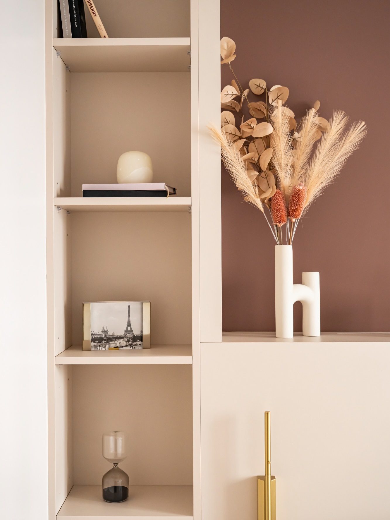 Tête de lit avec étagères contenant livres, vase décoratif et une photo en noir et blanc de la tour Eiffel.