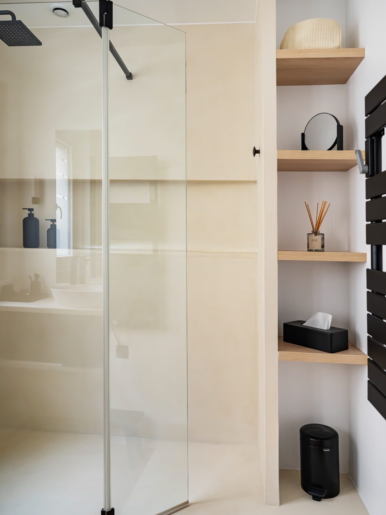 Douche moderne avec niche et paroi en verre et étagères en bois pour accessoires.
