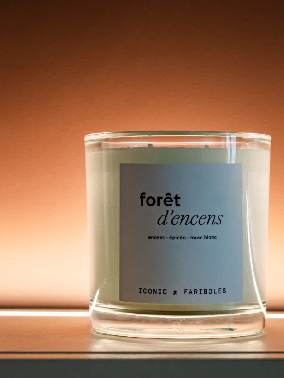 Bougie parfumée "forêt d'encre" avec étiquette blanche sur fond brun rosé.