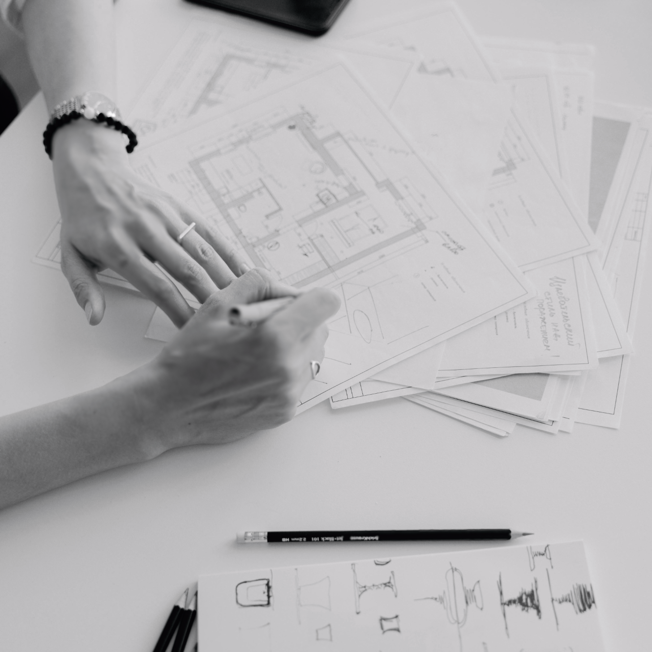 Des plans architecturaux et des esquisses dessinées à la main sur une table.