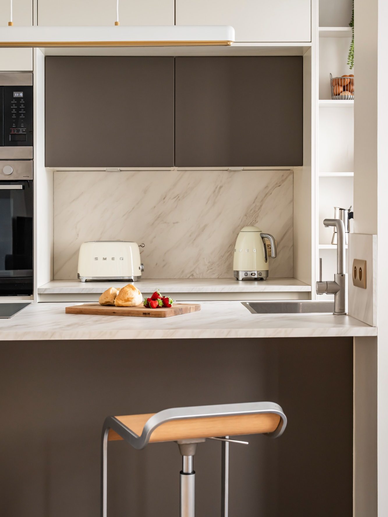 Cuisine moderne avec plans de travail en marbre et électroménagers élégants.