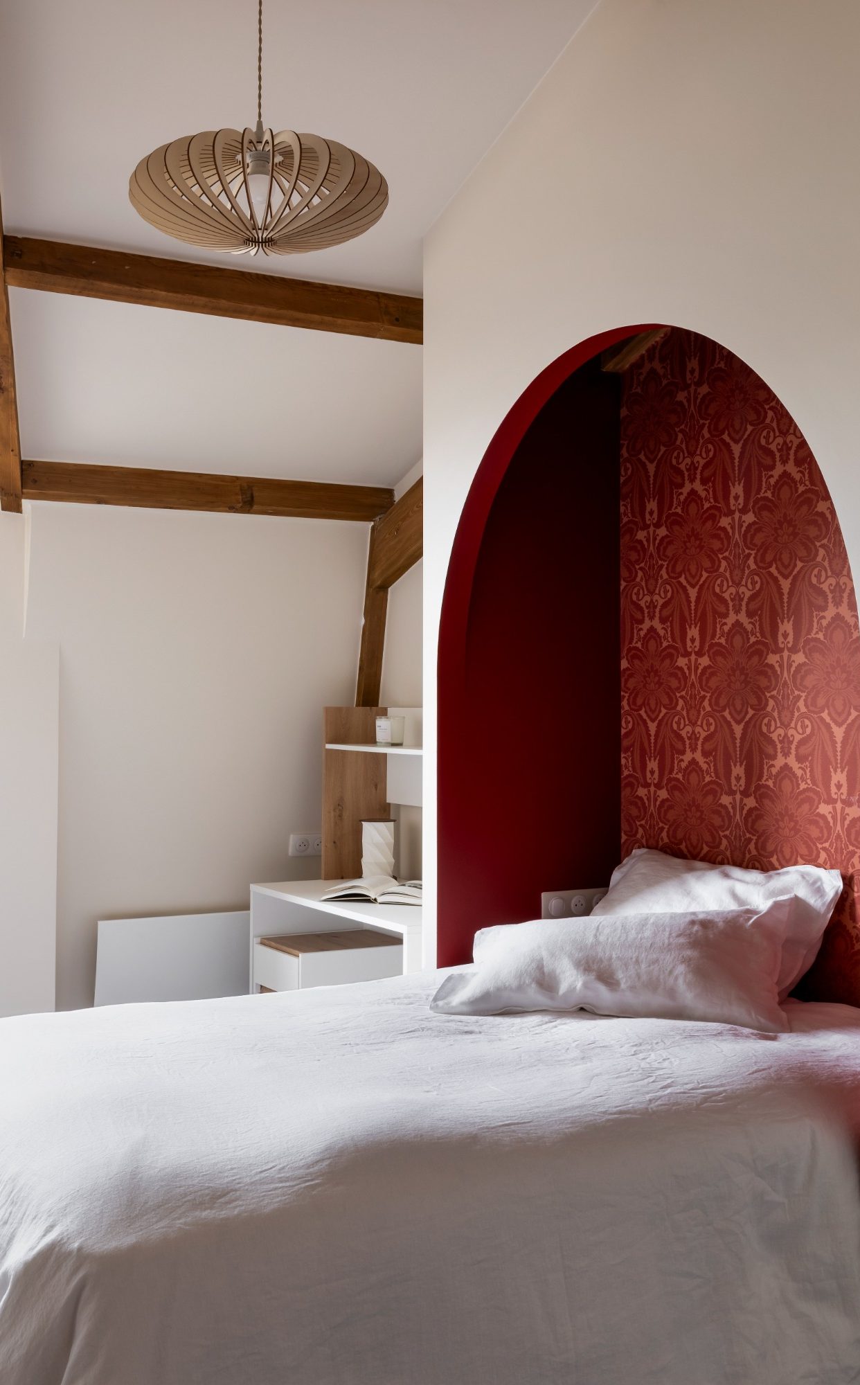 Chambre moderne avec alcôve pour le lit, intérieur de l'alcôve avec mur rouge, suspension centrale