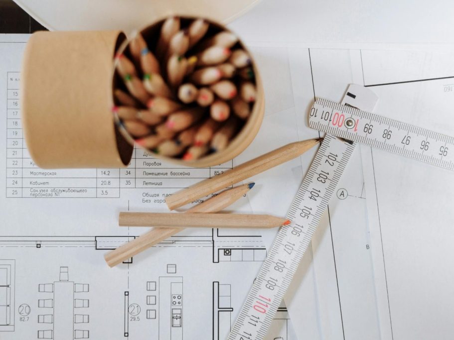 Bocaux de crayons de couleur avec des plans et des règles sur la surface de travail.